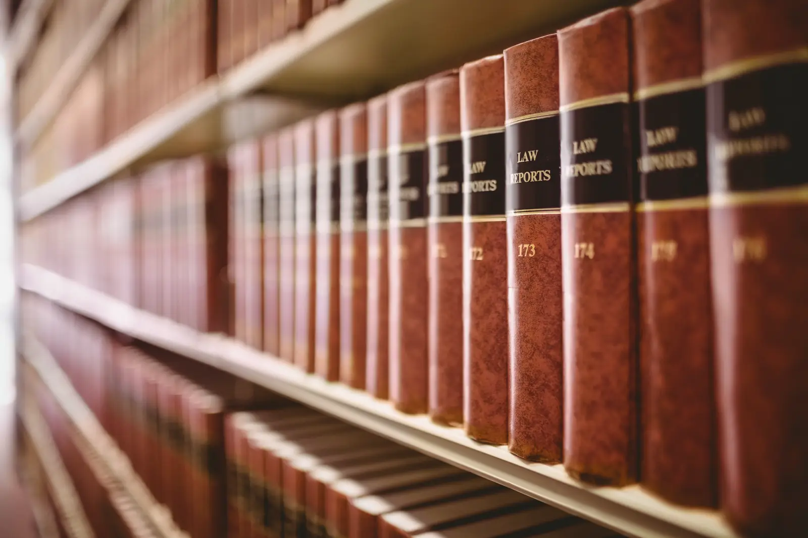A shelf of bound law reports, numbered volumes in red leather with gold lettering on the spines