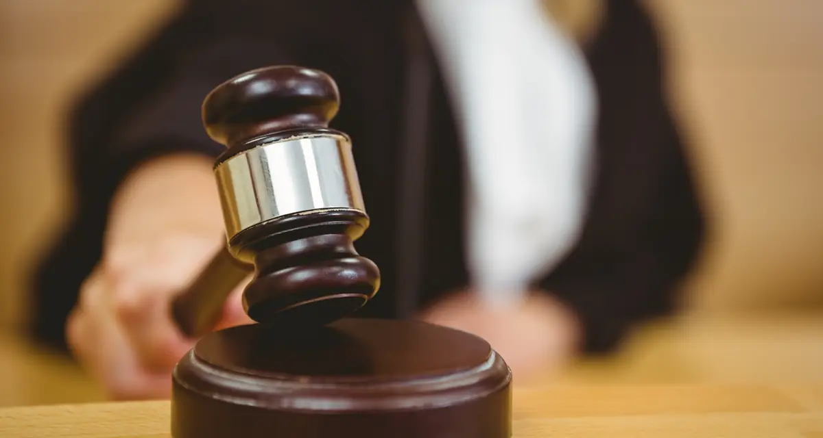 A judge's gavel coming down on its sounding block